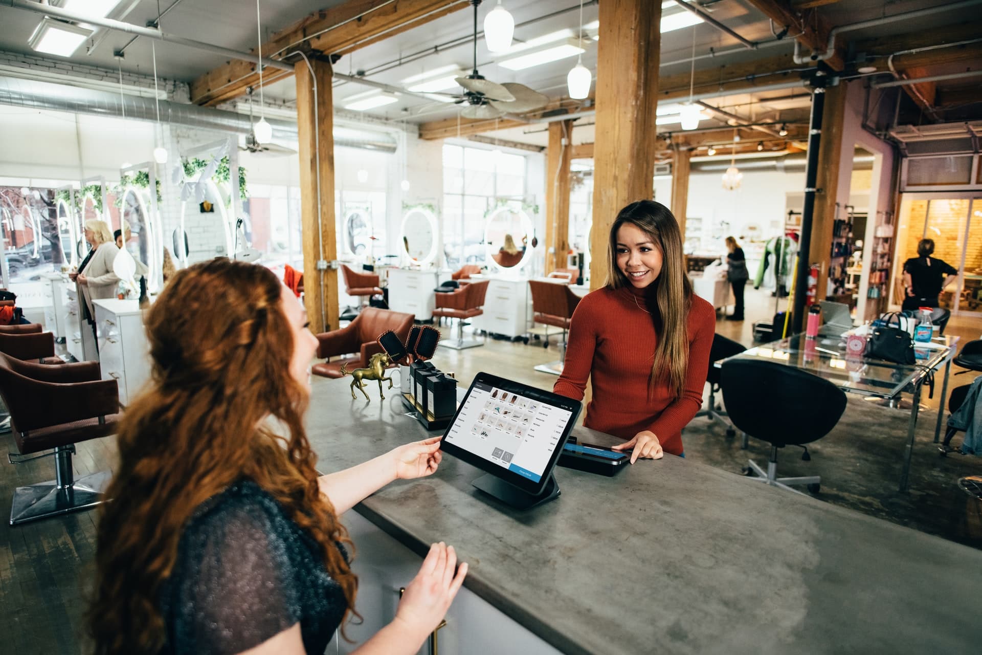 A cashier facing a customer in a red shirt.